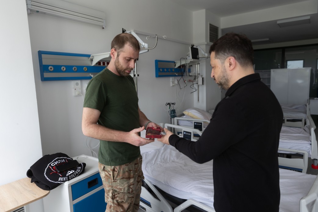 Президент України Воолоодимир Зеленський вручає нагороду військовому, який перебуває в лікарні в Рівненській області через поранення, 22 травня