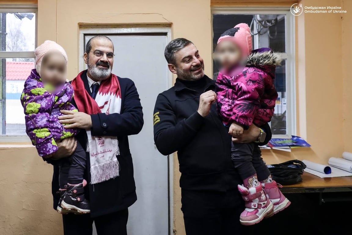 Дмитрий Лубинец и посол Катара в Украине держат возвращенных детей на руках