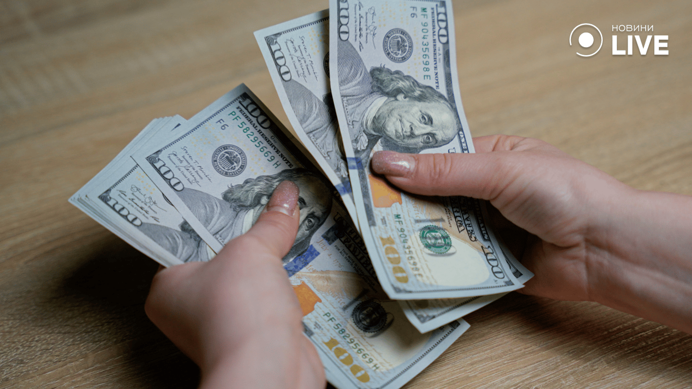 Жінка рахує доларові купюри 