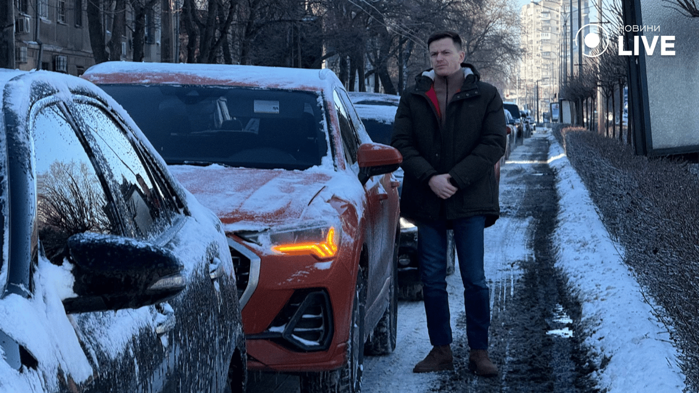 Чоловік стоїть біля машини