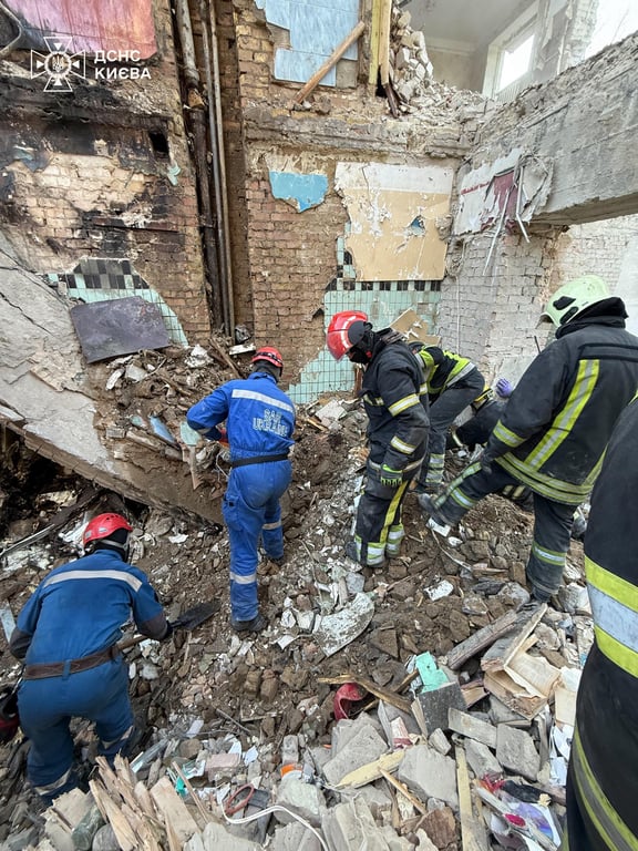 Rescuers dismantle the rubble of a destroyed nine-story building in Kyiv