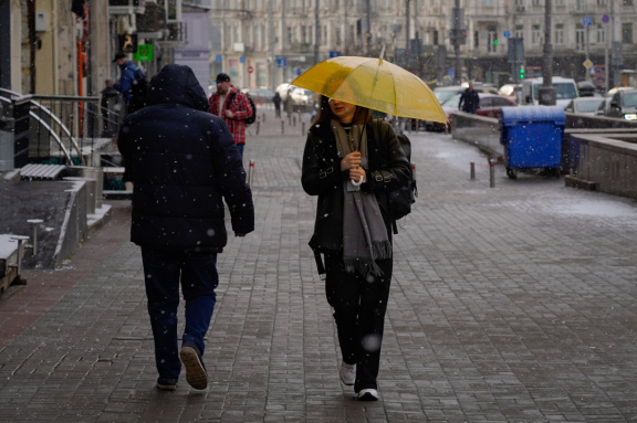 Люди идут под зонтиками в дождь