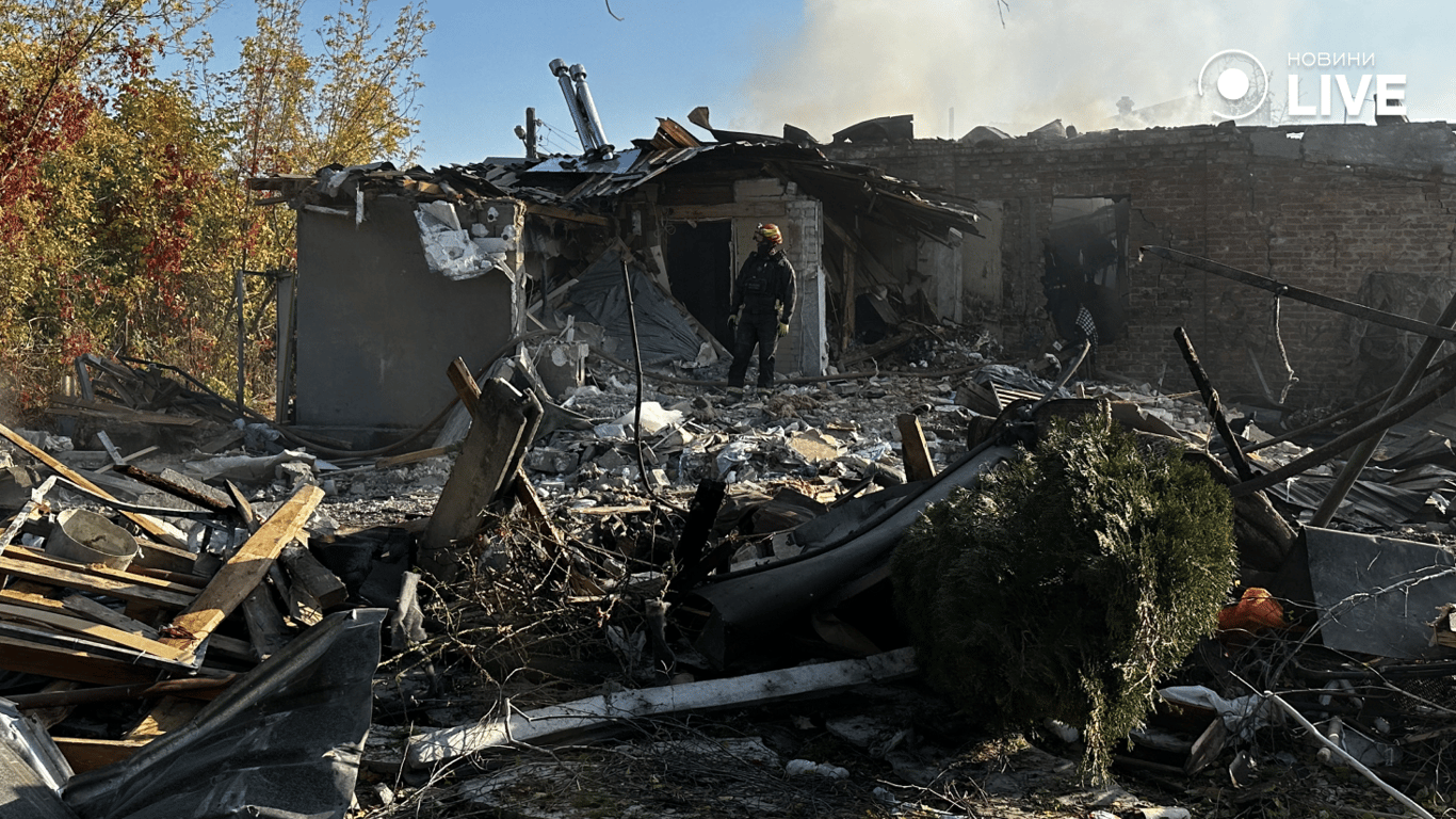  Рятувальник стоїть серед завалів зруйнованого будинку в Харкові