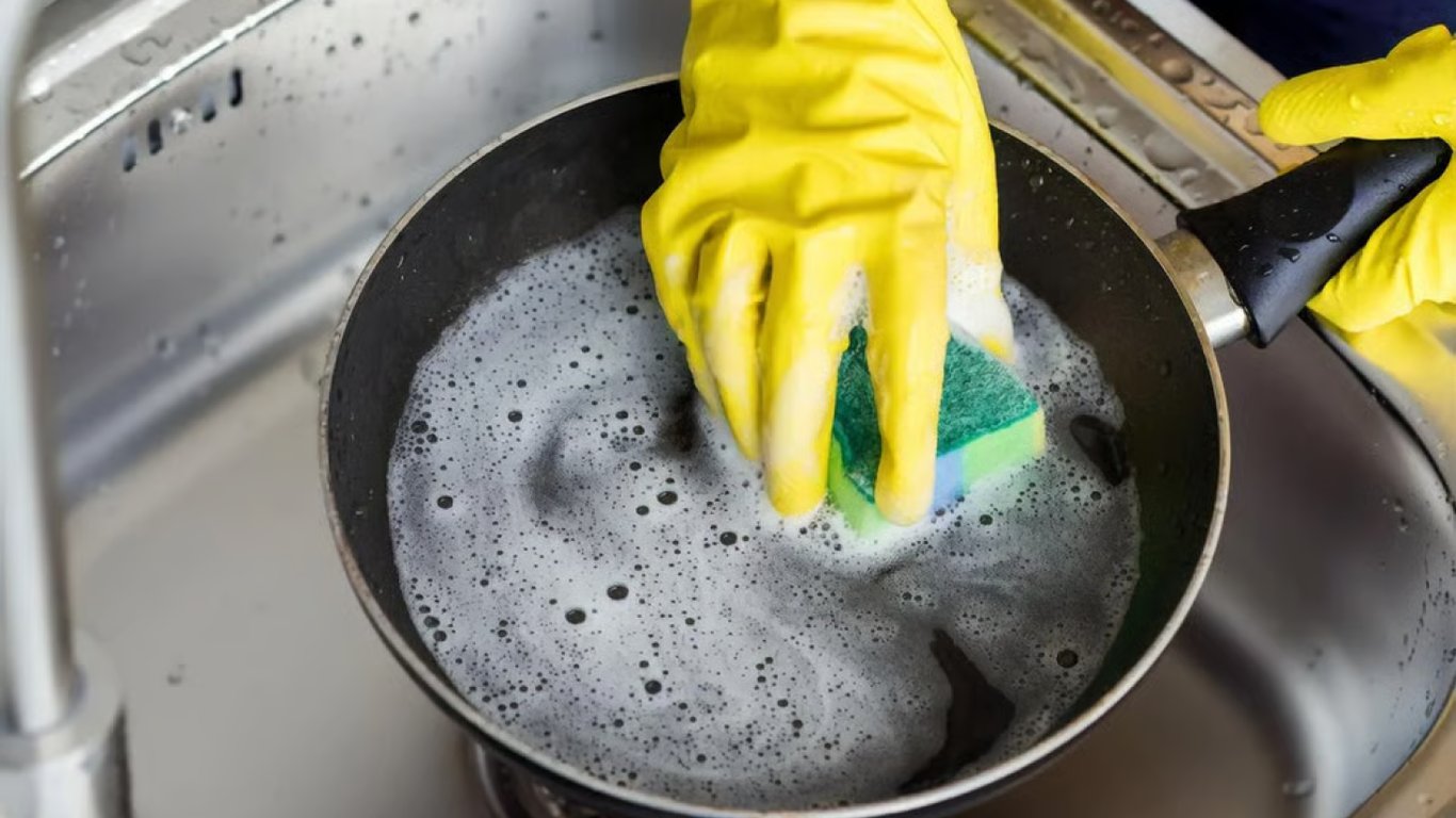 Людина миє пательню.