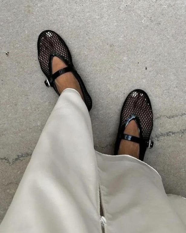 Девушка в черных сетчатых балетках