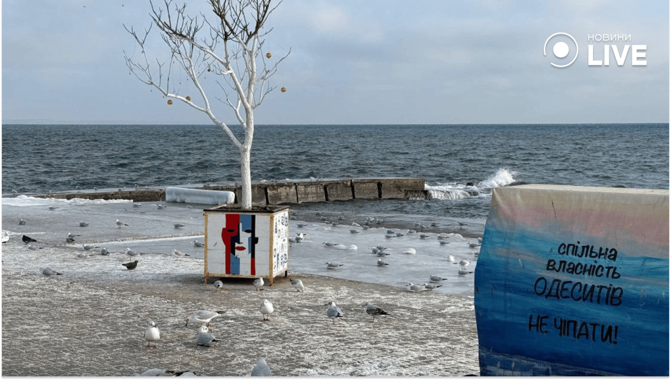 Люди гуляють зимовим узбережжям