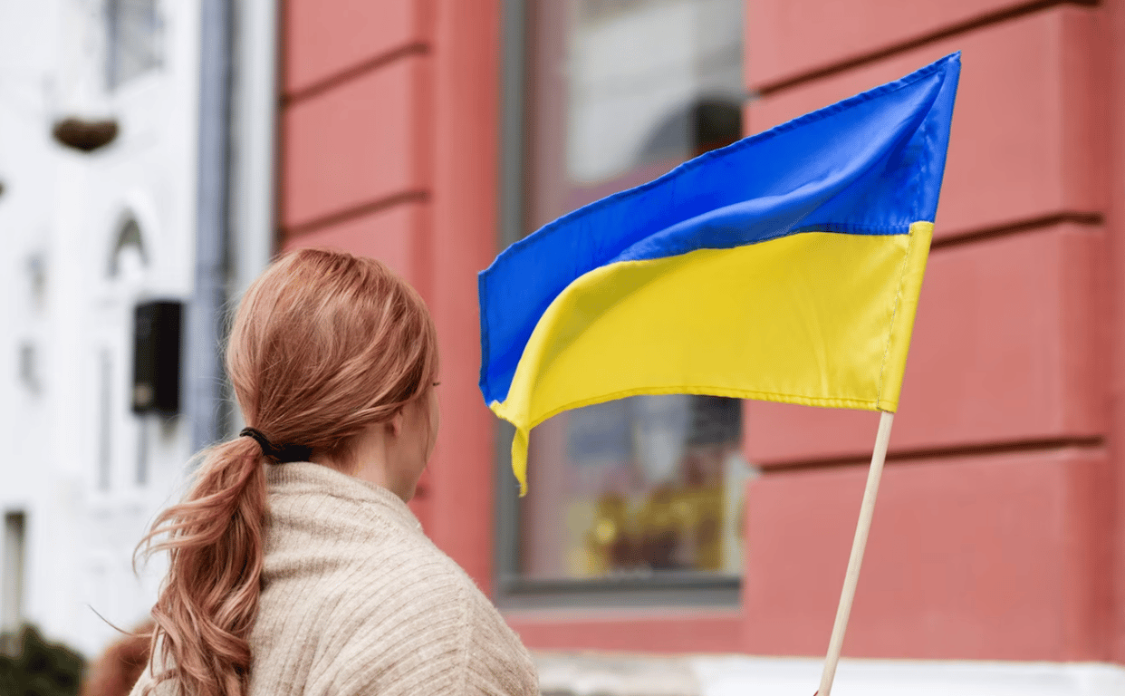 Женщина, держащая в руках украинский флаг