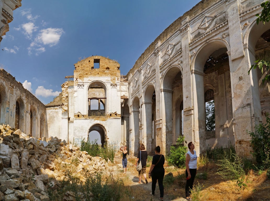 Фрагмент стіни старовинного храму з обваленим цегляним муруванням та оголеними арками.