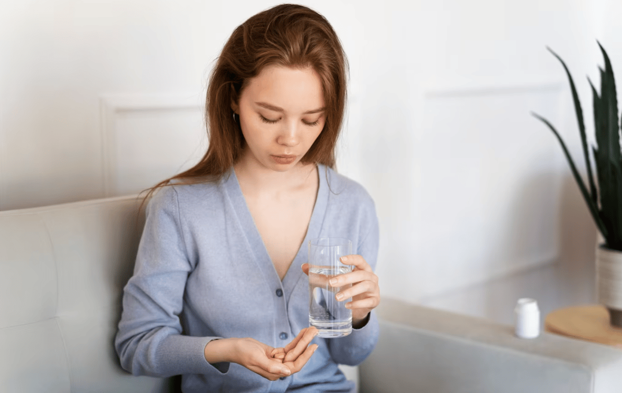 Молодая девушка, которая собирается пить витамины