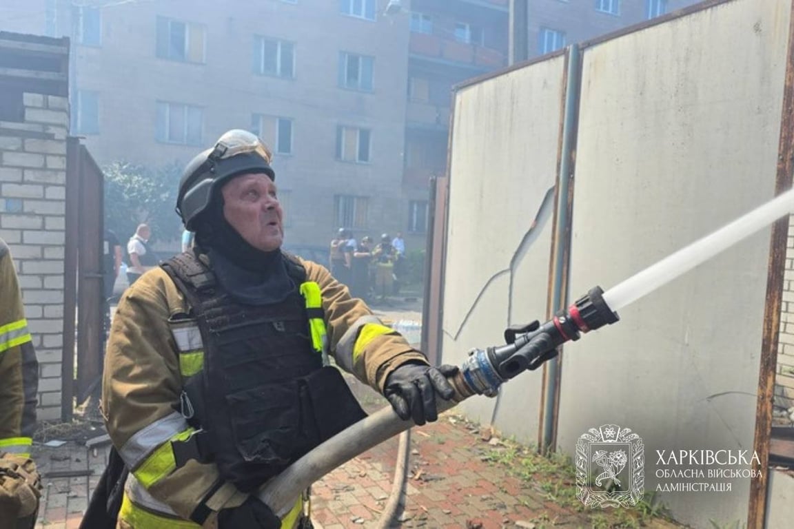 Рятувальник зі шланга поливає вогонь
