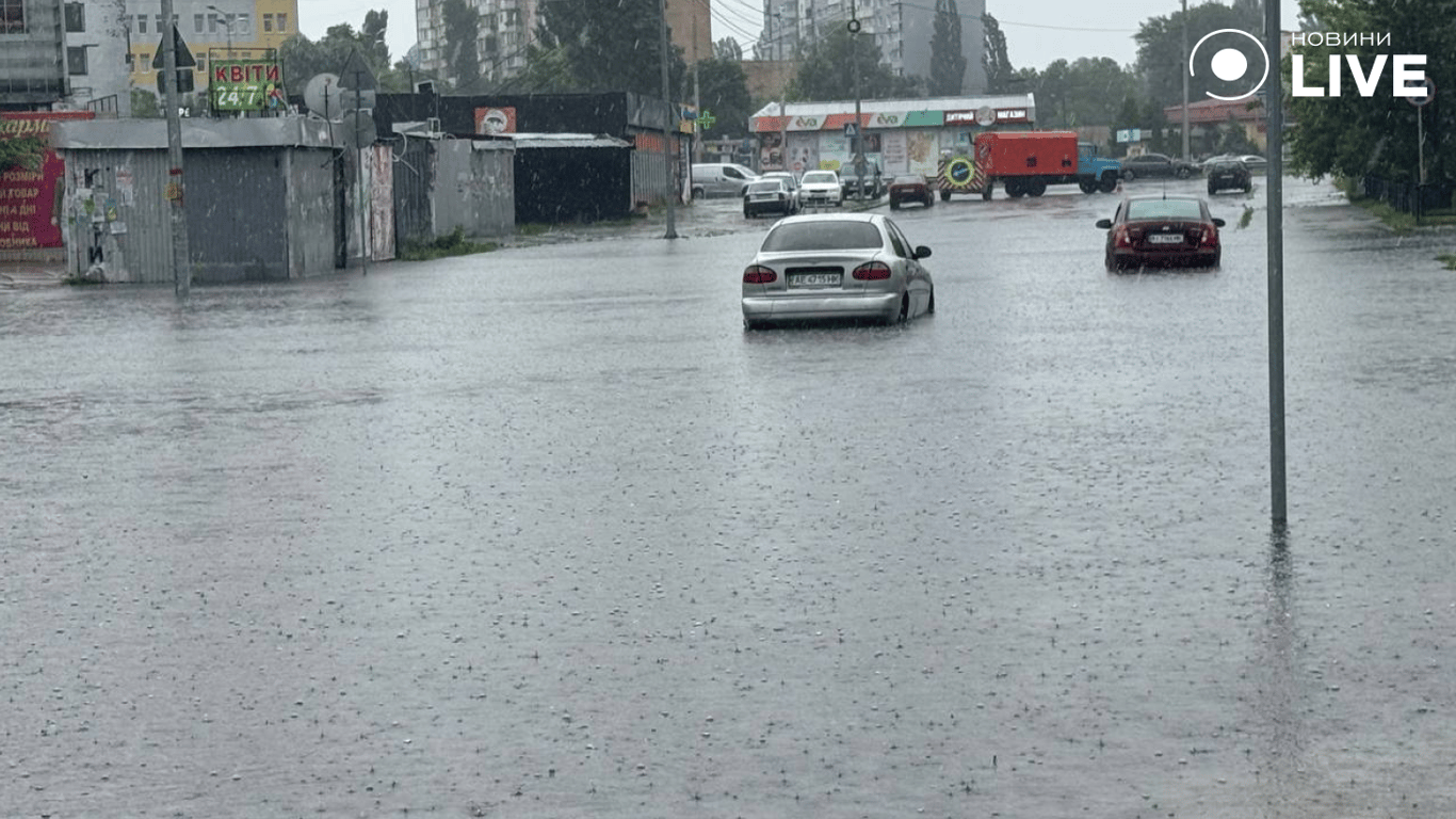 Автівки рухаються затопленими дорогами через дощ у Києві 12 червня