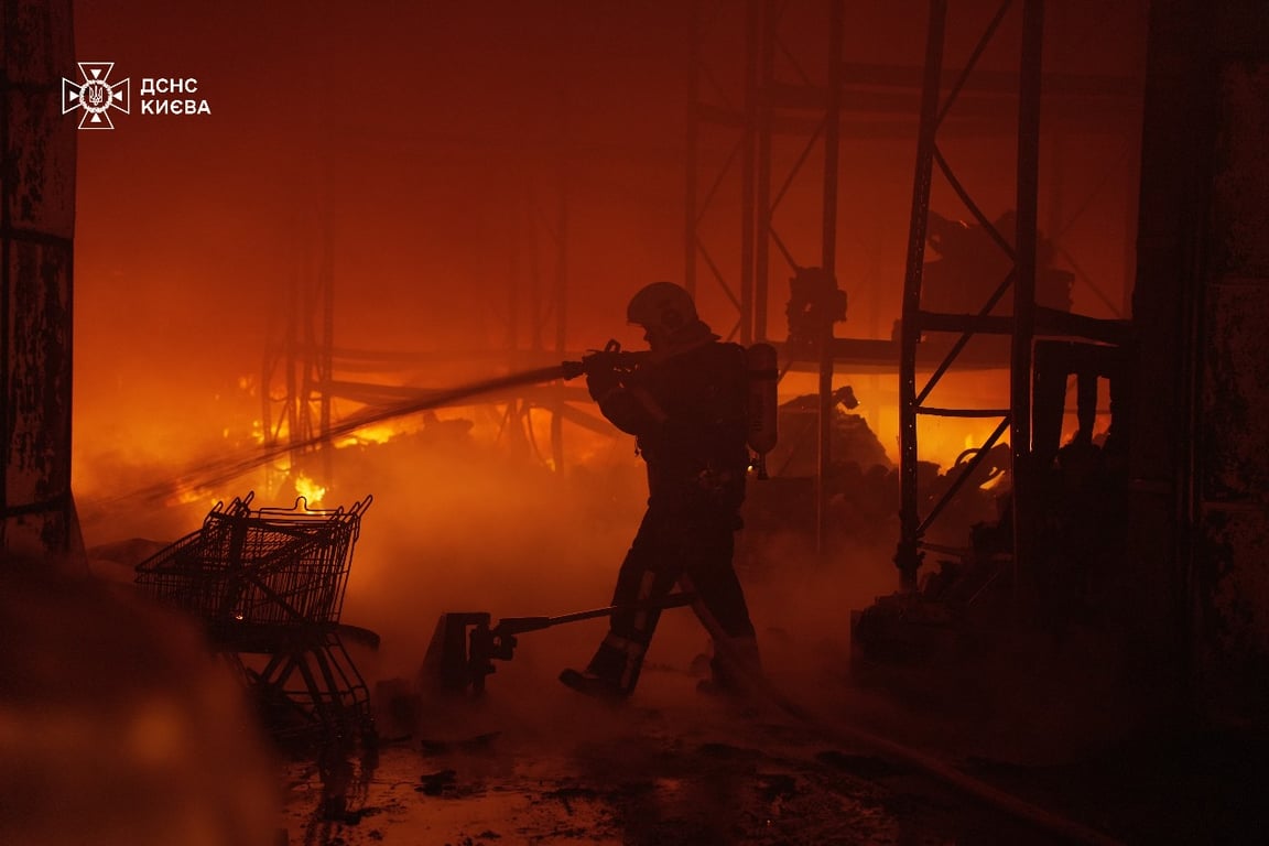 Рятувальник гасить пожежу у Києві після обстрілу 12 квітня