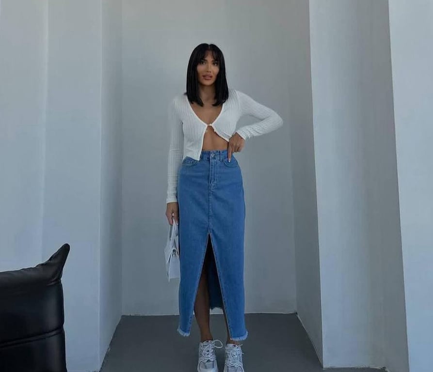 Світла джинсова спідниця нижче коліна з кросівками та топом