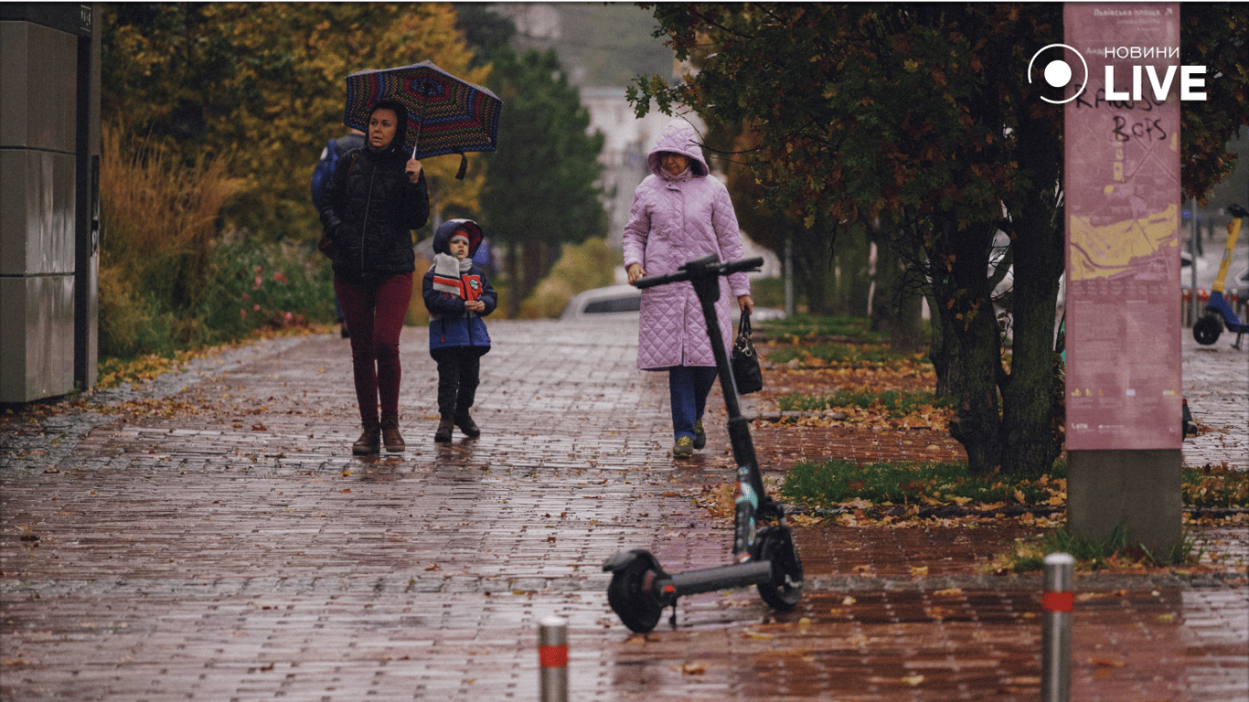 Люди идут по улице в дождь