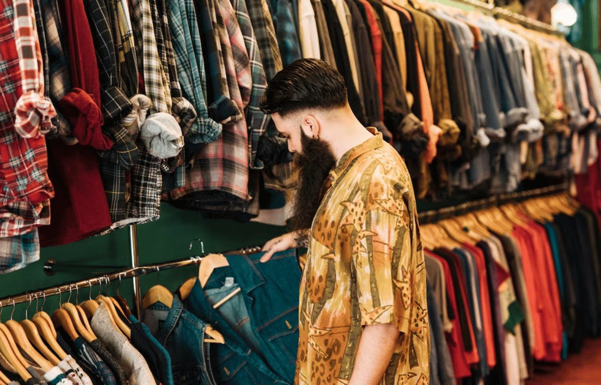 Мужчина, который выбирает одежду в секонд-хенде