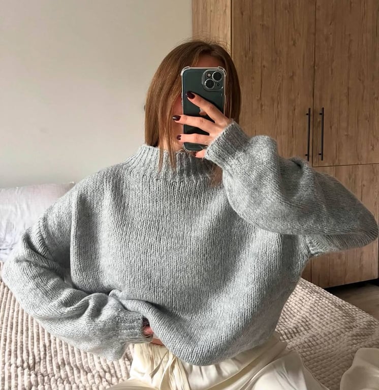 Серый свитер можно дополнить черными брюками.