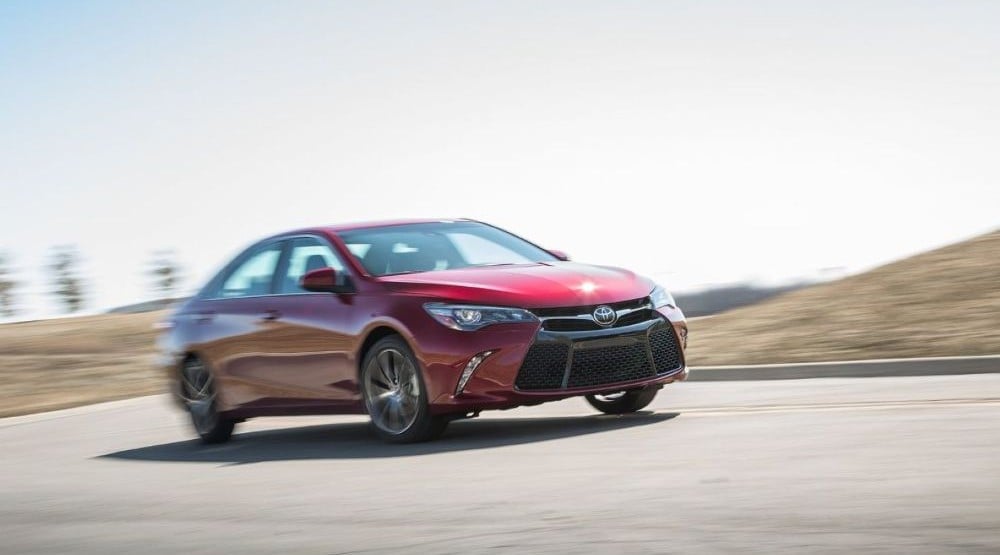 Червона Toyota Camry мчить дорогою