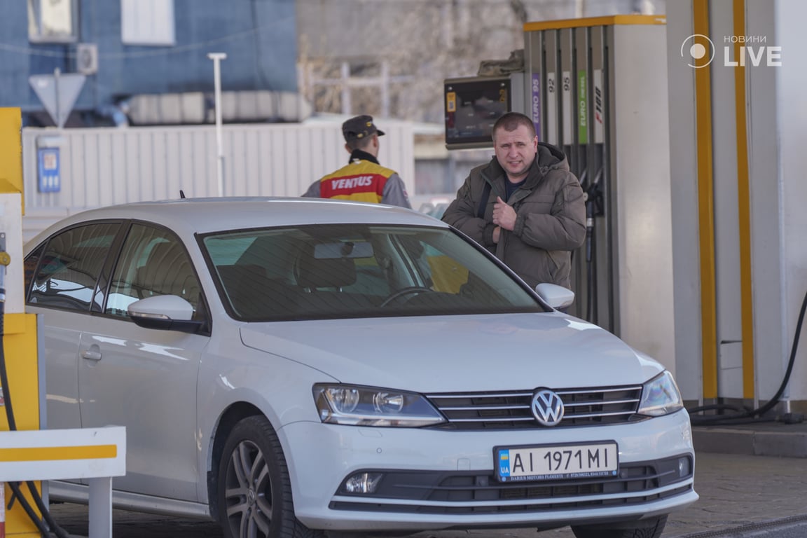 Чоловік заправляє автівку