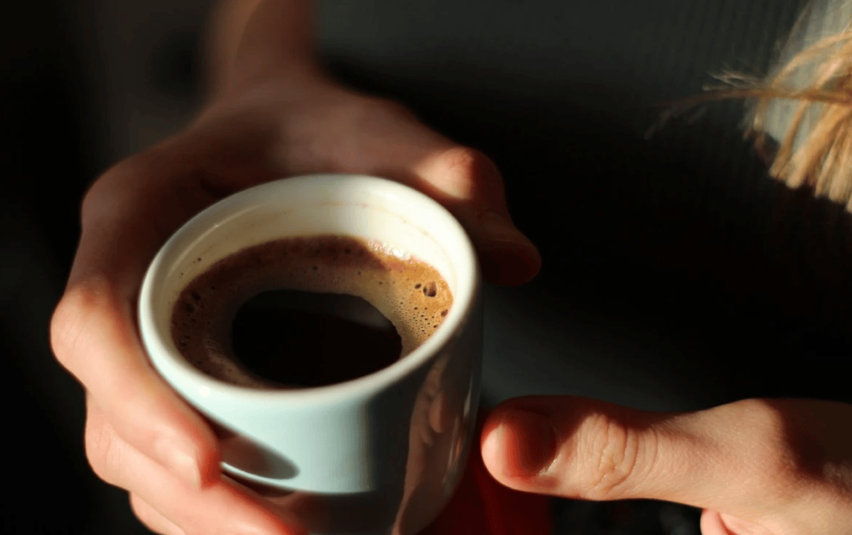 Человек, держащий чашку кофе в руках