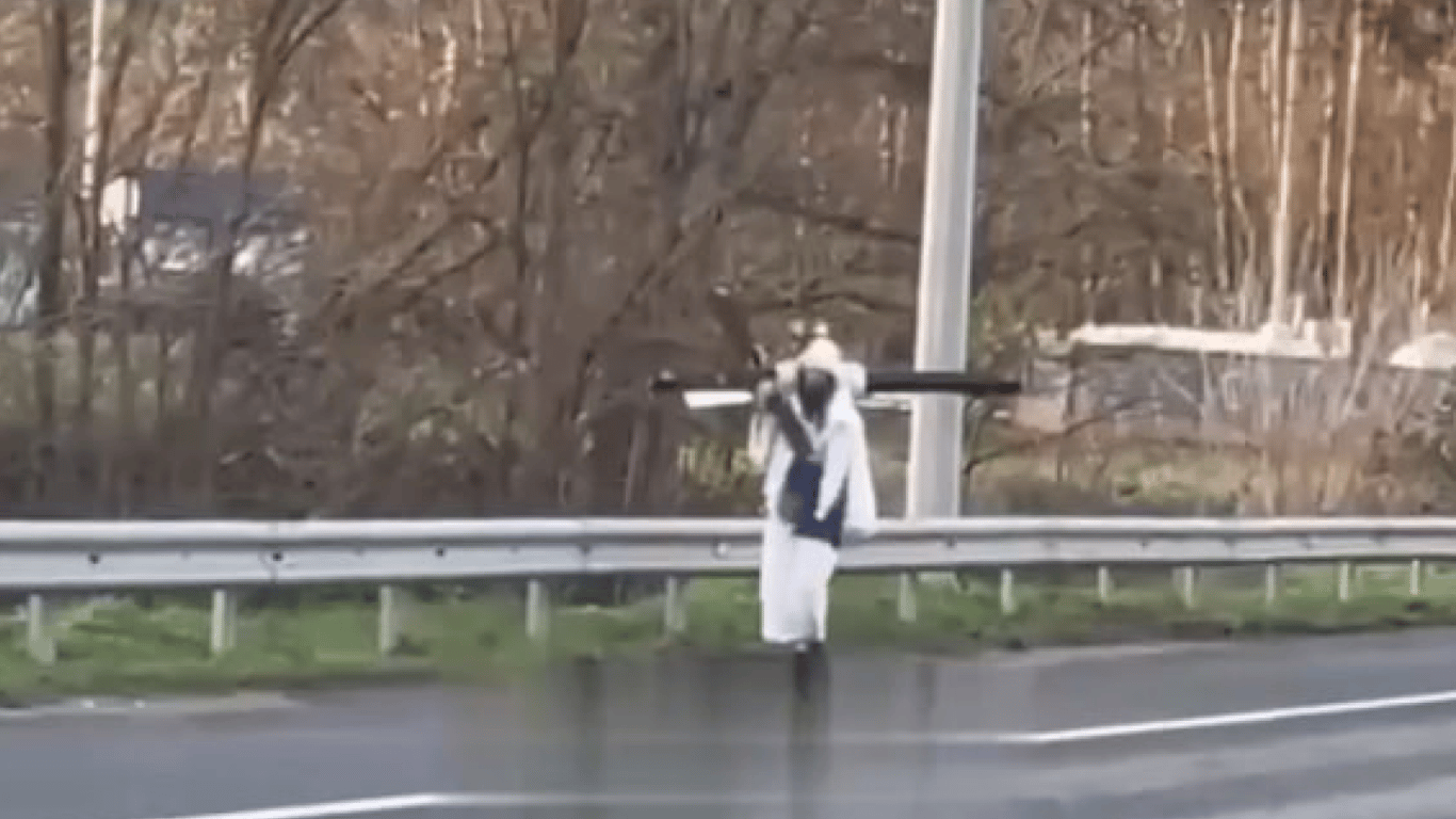 В Киев идет человек, который несет на плече огромный крест