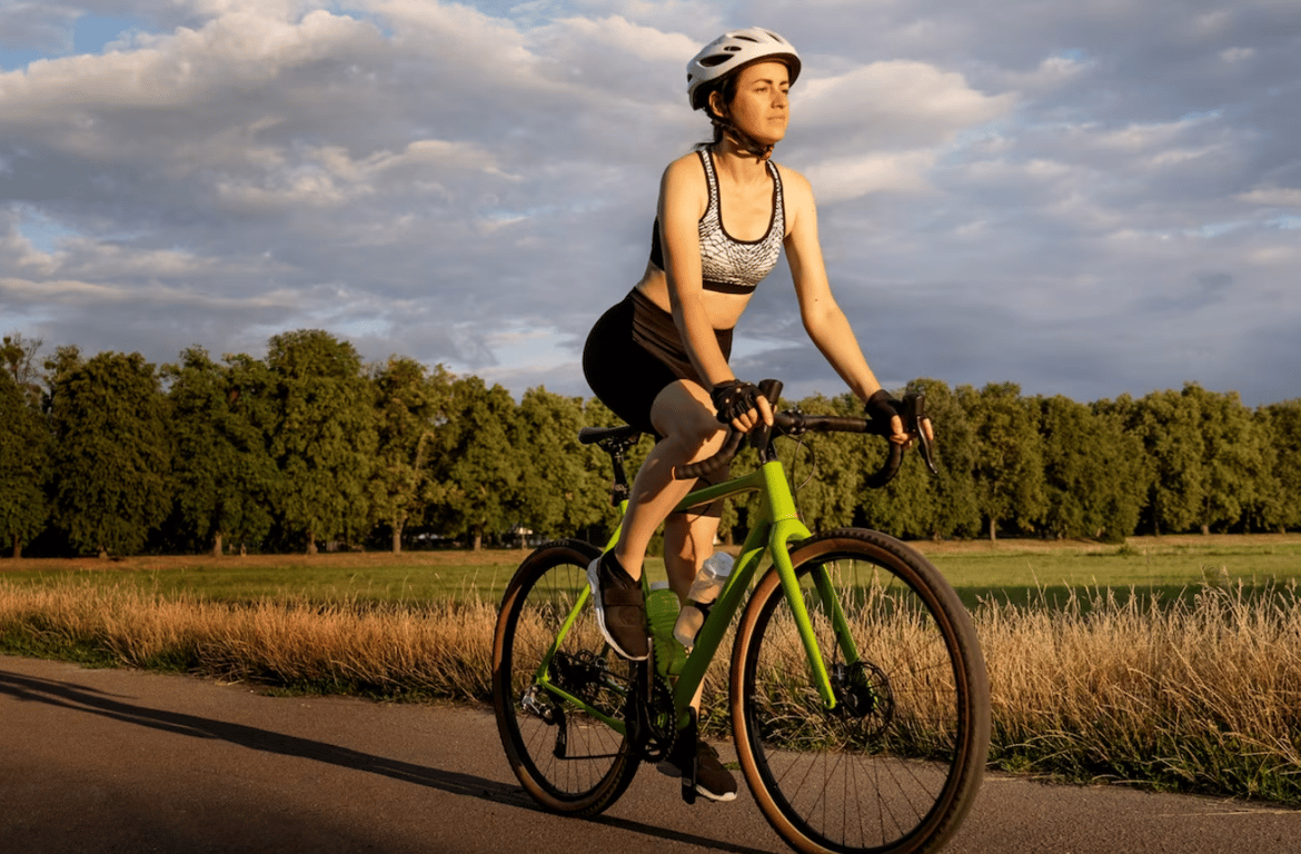 Молодая девушка, которая едет на велосипеде