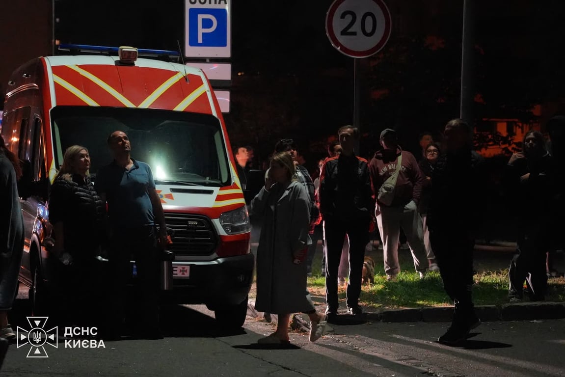 Мешканці пошкодженої багатоповерхівки біля службового автомобіля ДСНС