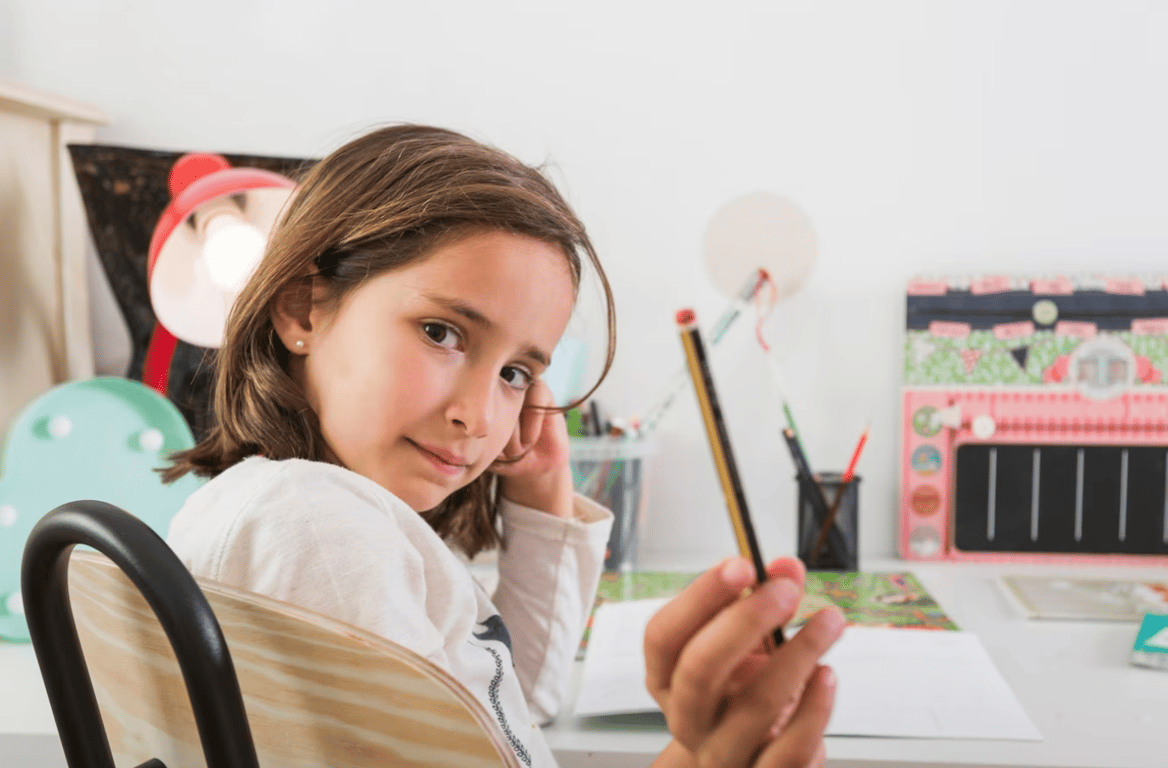 Ребенок, который держит в руке карандаш