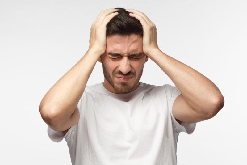 У мужчины болит голова из-за воздействия магнитных бурь