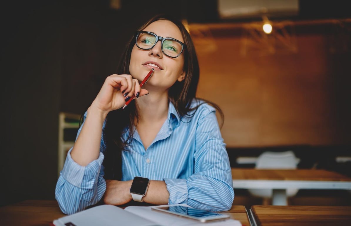Молодая девушка в очках возле тетради