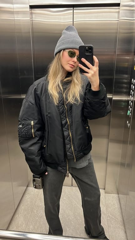Девушка в куртке-бомбере в лифте