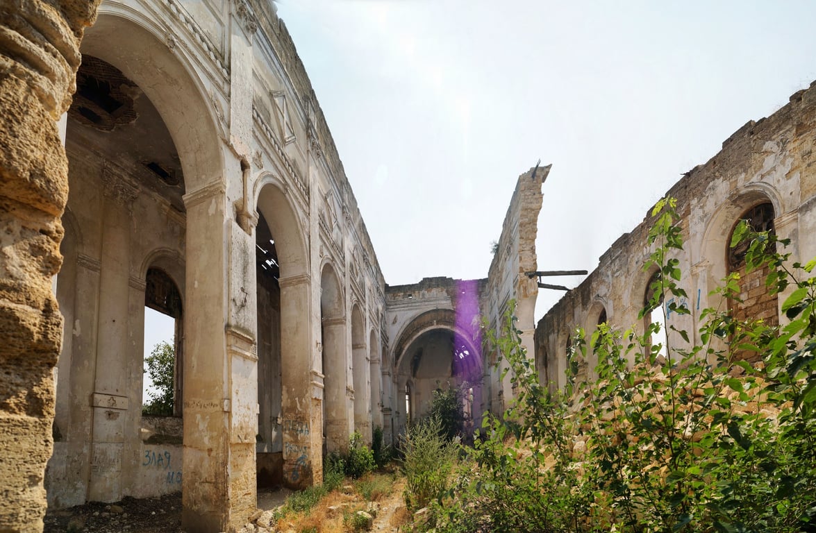 Фасад костелу німецьких колоністів XIX століття з тріщинами та пошкодженими арками.