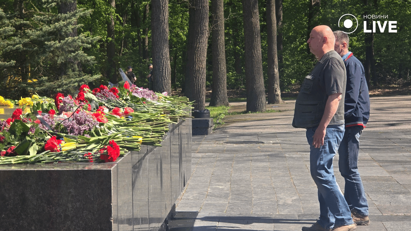 Чоловіки стоять біля мемооріалу у Харкові