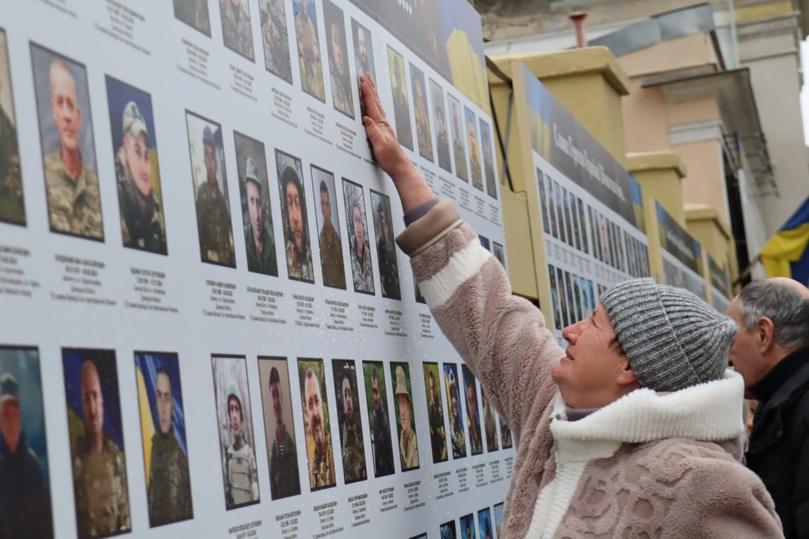 Жінка дивиться на фото рідної людини. Фото: Veterans Hub Odesa