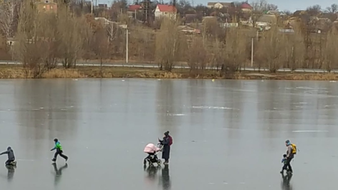 Зима в Киеве - мамочка с коляской гуляет по льду - фото